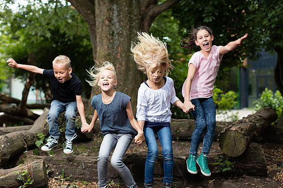 Kinder springen auf dem Schulhof