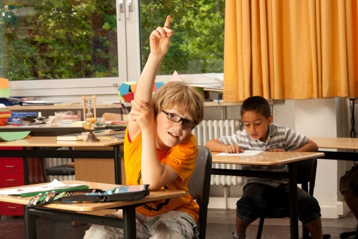 Junge meldet sich im Klassenzimmer